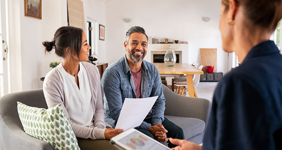 smiling couple meeting with financial adivsor about strategies for saving for retirement